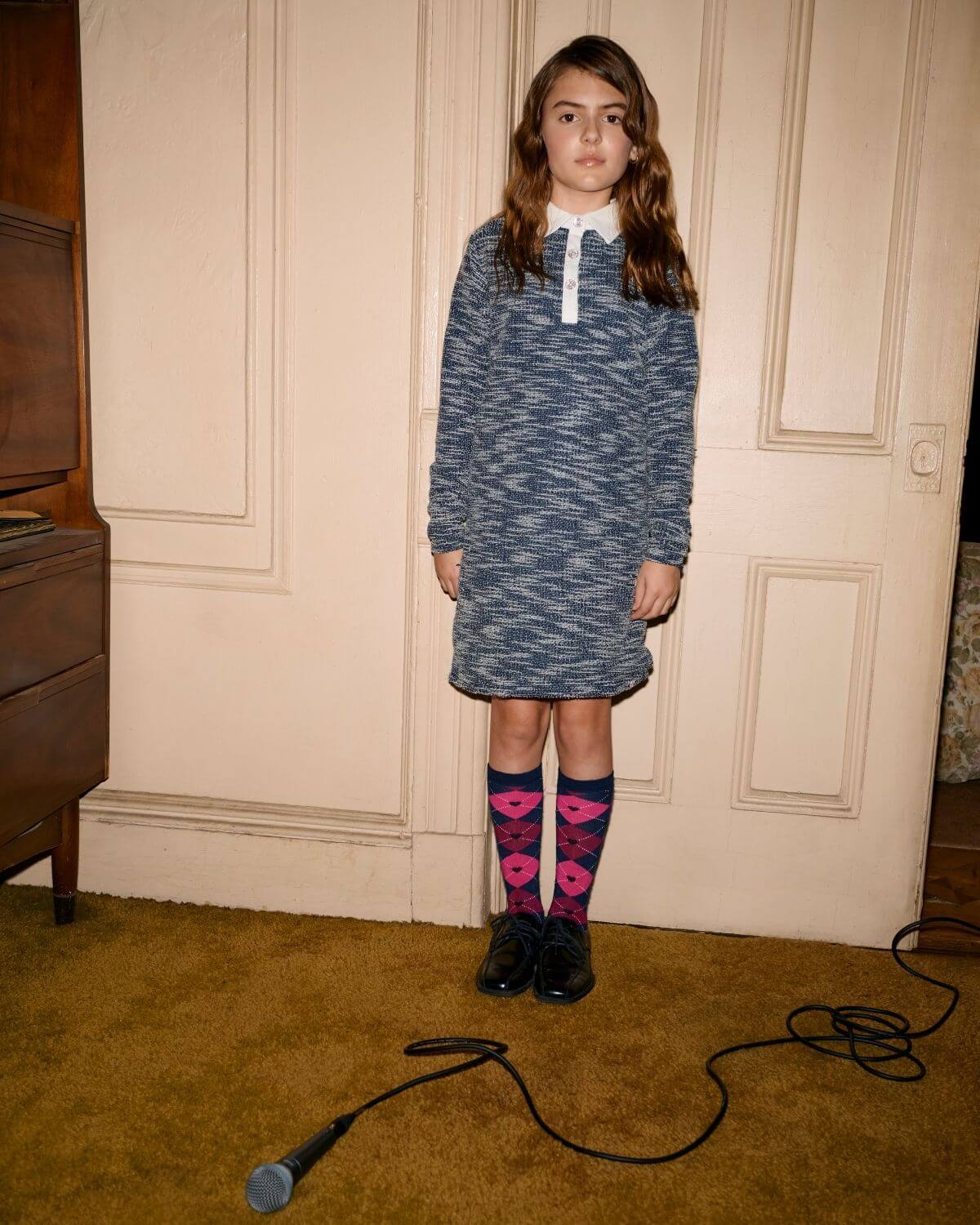 Girl wearing a Navy Tweed Polo Dress with a classic collar and sparkly buttons, styled with fun socks.