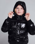 Girl wearing a stylish Black Glitter Puffy Coat with a shiny finish and hood, perfect for chilly days.
