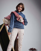 Girl wearing Dusk Blue Pullover Hoodie with pink jacket and cream pants, showcasing a stylish and cozy outfit.