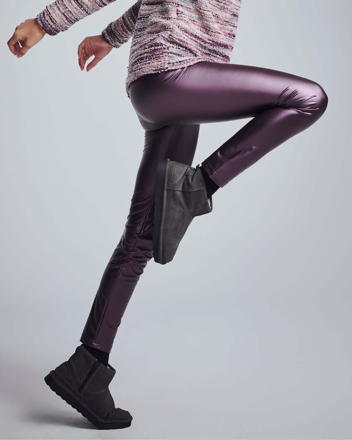 A child wearing Purple Shine Leggings in a playful pose, showcasing the vibrant purple color and stretchy fabric.