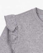 Heather Grey Ruffle Tee close-up showcasing soft fabric and playful ruffle detail on shoulder.