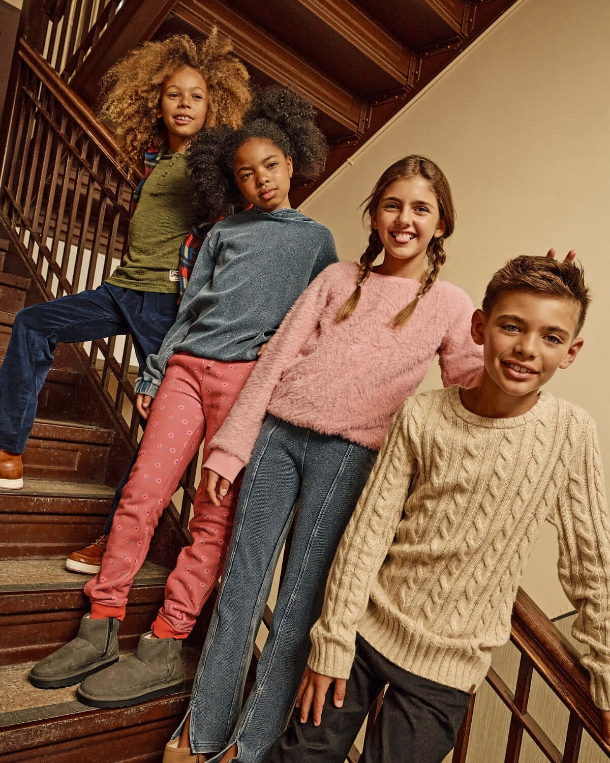 Four kids showcasing cozy outfits, including the Rose Quartz Stanton Joggers, on a staircase.
