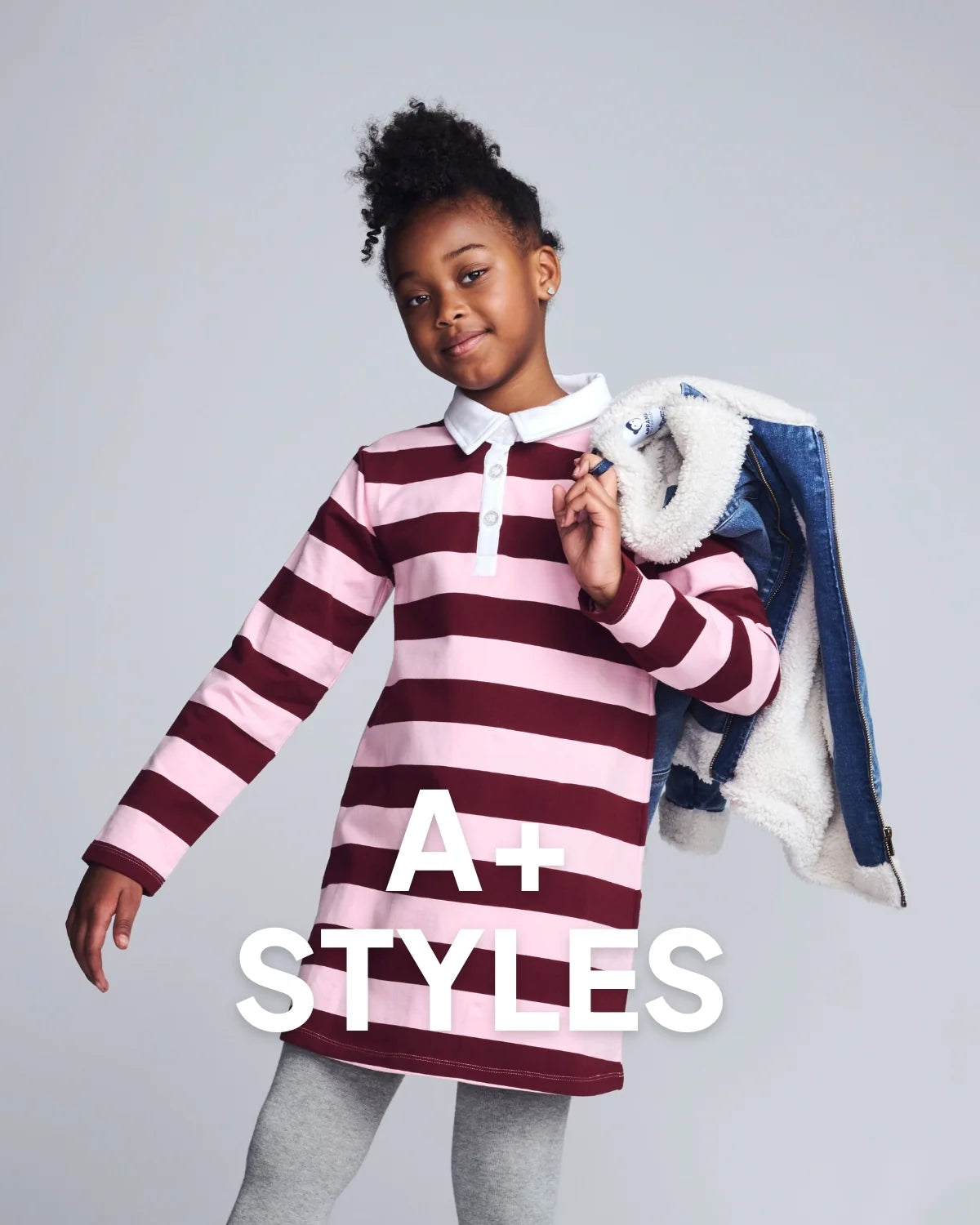 Child wearing a striped shirt with text 'A+ Styles' on a gray background