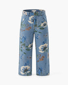 A pair of wide-leg cropped pants in a light blue denim-like fabric with an all-over floral print featuring white, blue, and green flowers, shown against a plain white background.