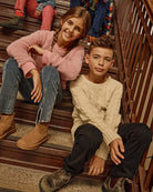 Kids wearing the Ivy Rose Willow Top and cozy sweaters sitting on stairs, showcasing stylish children's fashion.