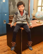 Child wearing Black Everyday Stretch Pants and a cozy sweater, sitting at a desk in a classroom.