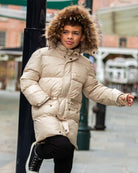 Boy wearing an Ivory Expedition Puffer Coat with a faux fur hood trim, perfect for cold weather adventures.
