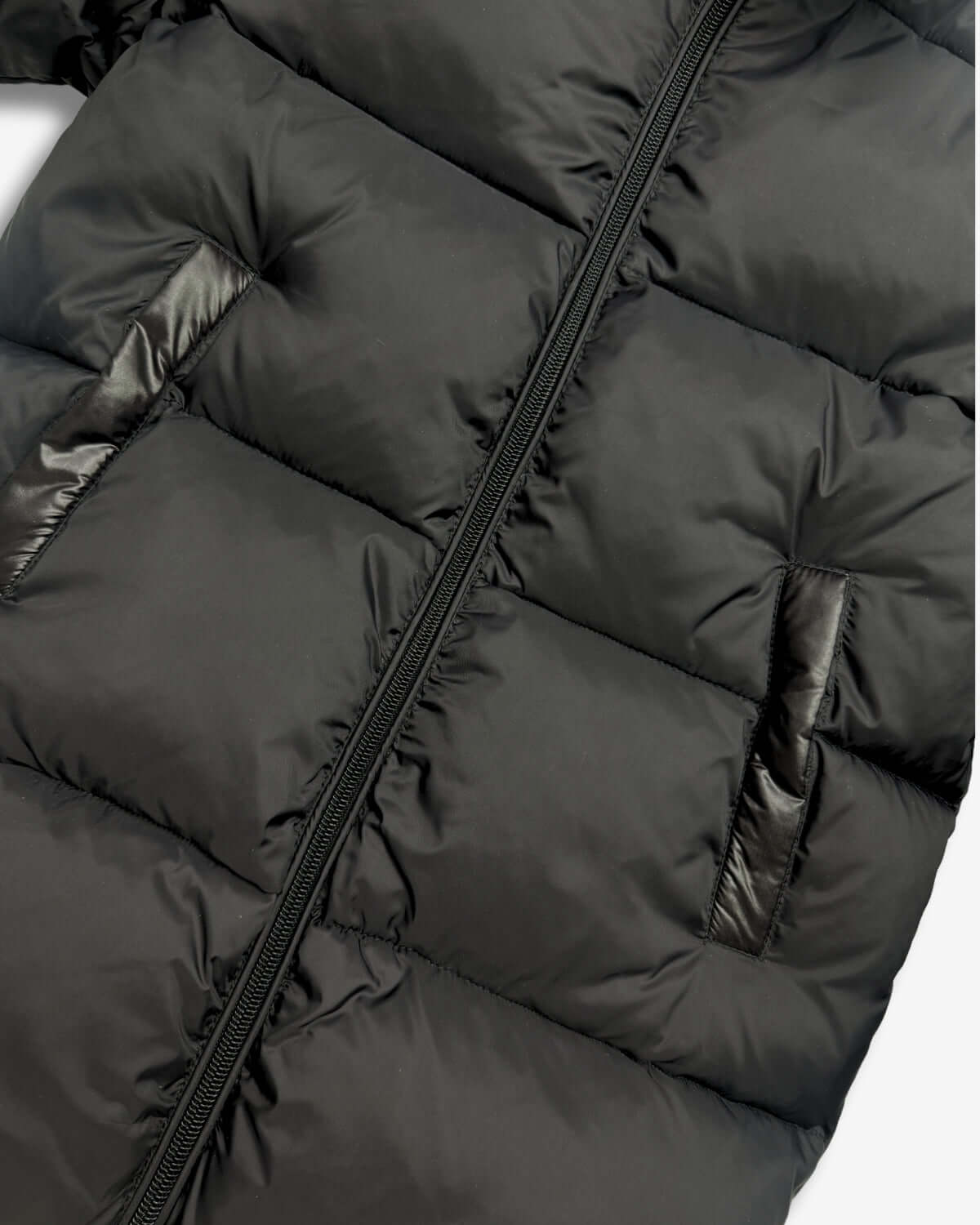 Black Park Ave Long Puffer jacket detail, showcasing sleek black fabric and puffy insulation.