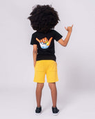 Cool kid rocking a Hang Loose Graphic Tee with vibrant surfboards, perfect for fun beach days or stylish school adventures!