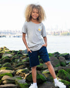 Stylish boy rocking a gray pocket tee with an ice cream graphic, perfect for summer adventures in kids clothes.