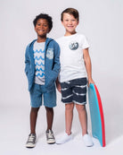 Two stylish boys in playful beach outfits, showcasing kids clothes that ride the wave of trendy and durable back-to-school fashion!