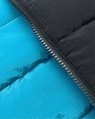 Close-up of Appaman's Blue Jewel Reversible Vest showcasing vibrant teal and classic black sides for stylish kids' outfits.