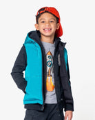 Stylish boy in Blue Jewel reversible vest, ready for back to school adventures with a playfully cool look.