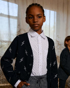 Cool kid rocking the Electrifying Obi Cardigan with lightning bolts—stylish and cozy for any back-to-school adventure!