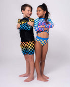 Vibrant kids rocking the Happy Surfing Rash Guard and swim trunks, ready for sun-soaked beach adventures in style!