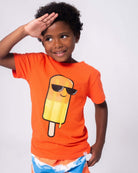 Stylish kid wearing orange tee with a cool popsicle graphic, perfect for fun summer adventures in kids clothes.