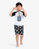 A cool kid rocking skull and bones swim trunks, ready for fun in the sun with stylish shades. Ideal for adventurous back-to-school vibes!