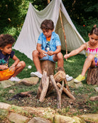 Kids sharing smiles and s'mores around a campfire, dressed in playful, high-quality Appaman summer gear.
