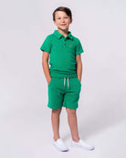 Stylish boy in Kelly Green Fairbanks Polo and matching Preston Shorts, ready for fun summer outings!