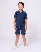 Stylish boy in navy shark resort shirt and matching shorts, ready for beach fun in high-quality kids clothes!