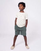 Stylish boy in a palm-print tee and comfy shorts, ready for summer adventures in high-quality kids clothes!