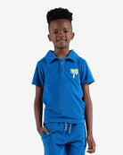 Fun-loving kid rocking the blue Surf the Web Fairbanks Polo with tropical palm embroidery, perfect for stylish back-to-school vibes.