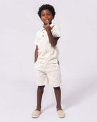 Stylish boy wearing a light polo and shorts, ready for summer fun and adventures in high-quality kids clothes.