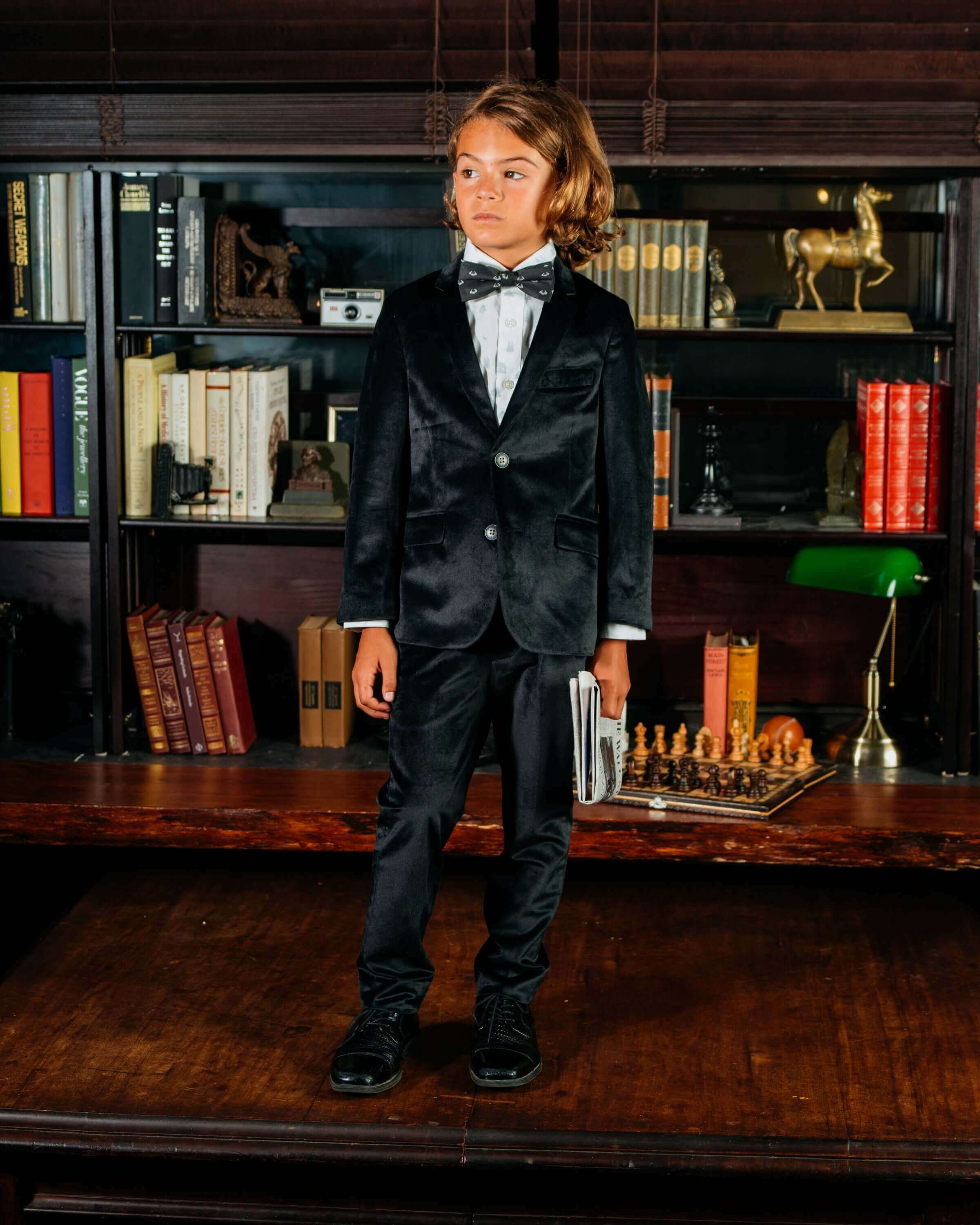 Child wearing a Black Velvet Suit Blazer paired with a bow tie, ready for special occasions.