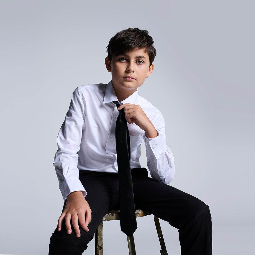 Stylish boy in a premium white dress shirt and tie, ready for formal fun in trendy kids clothes!