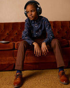 Stylish kid in a Midnight Floral button down, rockin’ headphones and cool shoes, ready for any back-to-school adventure!