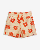 Sunny daisy-patterned resort shorts for kids, made from ultra-soft terry cloth with adjustable waist and pockets.