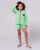 Stylish girl in mint Majorca shorts and matching hoodie, rocking shades for a fun summer vibe!