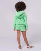Stylish girl in mint Majorca shorts and matching hoodie, ready for summer adventures in high-quality kids clothes.