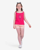 A joyful girl in a vibrant tank and multicolor shorts, ready to shine in high-quality kids clothes for back to school fun!