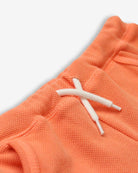 Close-up of peach Majorca shorts showcasing cozy fabric and playful drawstring, perfect for stylish summer adventures!