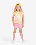 Bright-eyed kid rocking a smiley tee and pink shorts, the ultimate stylish combo for back-to-school fun in kids clothes!
