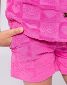 Stylish pink resort shorts with heart patterns for kids, perfect for sunny days and beach adventures!