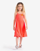 Joyful girl in a Neon Orange Carrie Dress with sunshine patch, ready for summer fun and adventure!