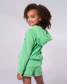 Stylish girl in mint hoodie, showcasing playful hearts, ready for adventures in high-quality kids clothes!