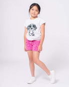 Stylish girl in playful Dalmatian tee and pink shorts, ready for fun adventures in high-quality kids clothes.