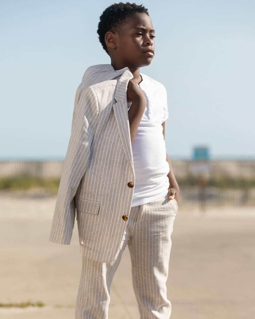 A confident boy rocking the Sand Stripe Linen Relaxed Suit—stylish kids clothes ready for summer fun!