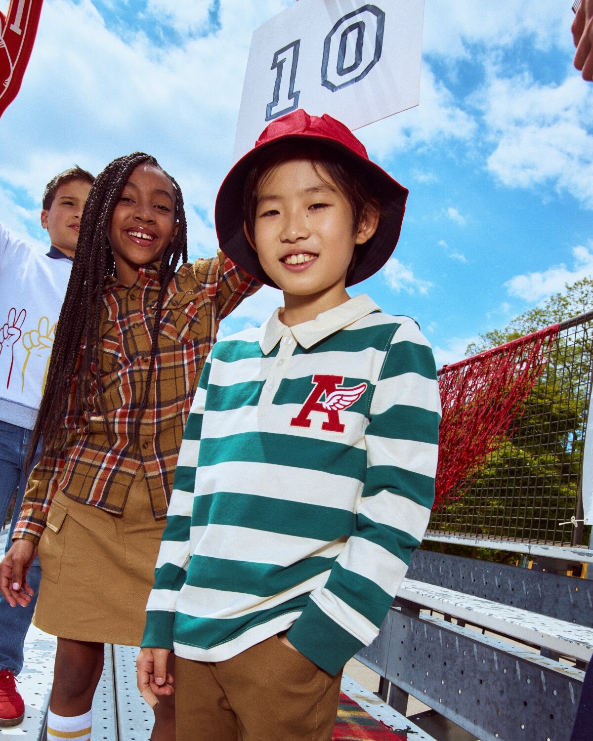 Children wearing stylish clothing with a clear blue sky in the background