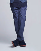 Person wearing a blue suit with matching shoes on a light gray background