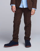 Person wearing brown corduroy pants with a plain background