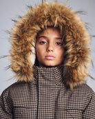 Person wearing a coat with a fur hood against a gray background