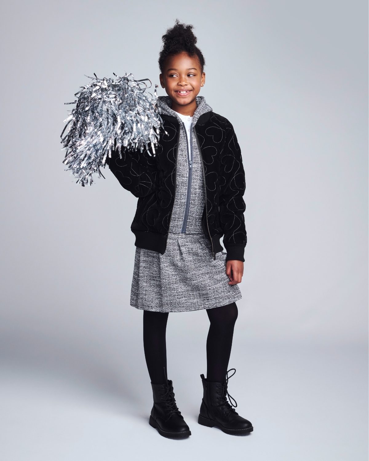 Child holding tinsel against a plain background