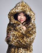 Child wearing a fur-lined coat with a hood on a gray background