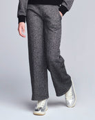 Person wearing gray wide-leg pants with a plain background