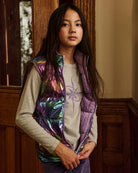 A girl wearing a lavender puffer vest, standing on a staircase. Appaman Fall/Winter 2026 collection.