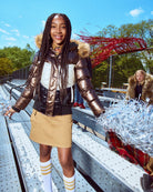 Person wearing a metallic jacket with fur hood in an outdoor setting